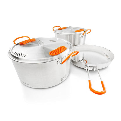 Experience the ideal mix of durability and style with the GSI Outdoors Glacier Base Camper cookware, featuring three stainless steel pots and pans with vibrant orange handles and knobs, perfect for gourmet cooking adventures.