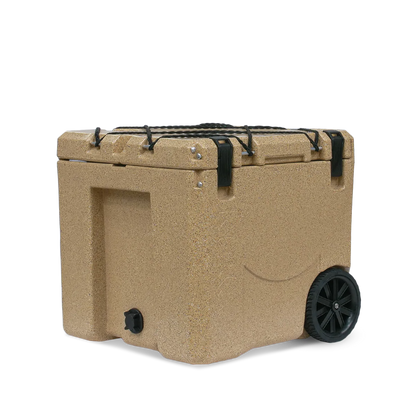 The Canyon Coolers Mule 30 Cooler in tan has strong hard wheels, black handles, and clasps. It includes a front spout for easy draining, perfect for outdoor adventures.