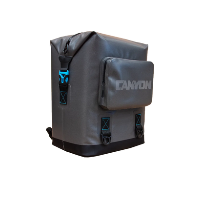 Gray rectangular "Nomad Go Soft Cooler Backpack" by Canyon Coolers features a front zip pocket, blue accents, and "Canyon" printed on the front. Its leak-proof design ensures both style and functionality for your adventures.