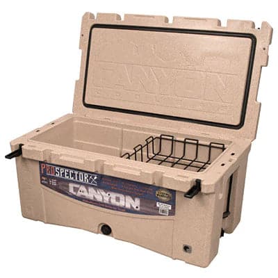 The Prospector 103 Raft Cooler from Canyon Coolers is a large, bear-resistant beige cooler with an open lid, black handles, and a removable wire basket inside, perfect for keeping your supplies safe in the wild.